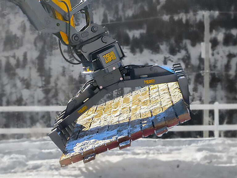 Excavator with mat grapple attachment lifting a wood rig mat