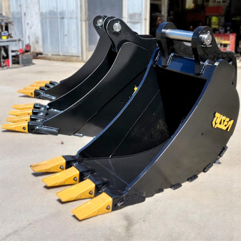 Three heavy-duty excavator digging buckets lined up on gravel, designed for trenching and earthmoving