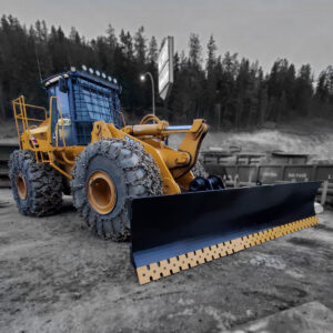 John Deere wheel loader with a snow blade installed containing a serrated edge