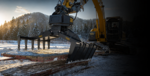 Excavator with mat grapple attachment lifting wood access rig mats