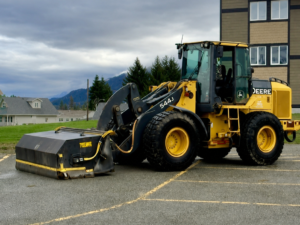 John Deere wheel loader with pickup broom attachment